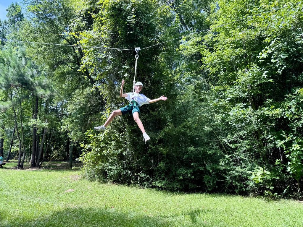 Youth on zipline - ropes course at Camp Pearl